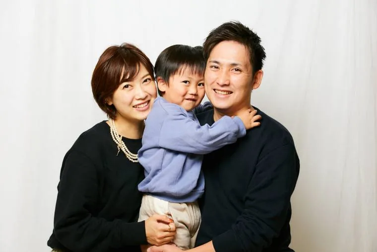 お母さんとお父さんに挟まれて笑う小さな男の子