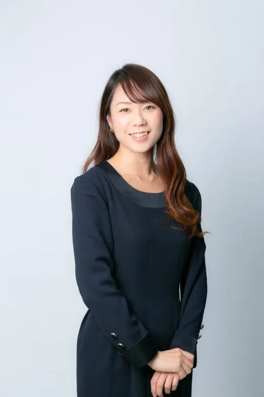 明るい背景の前で立つ女性のプロフィール写真