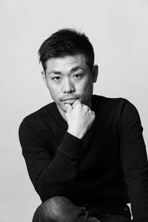 モノクロで、あごに手を当ててこちらを見る男性のプロフィール写真